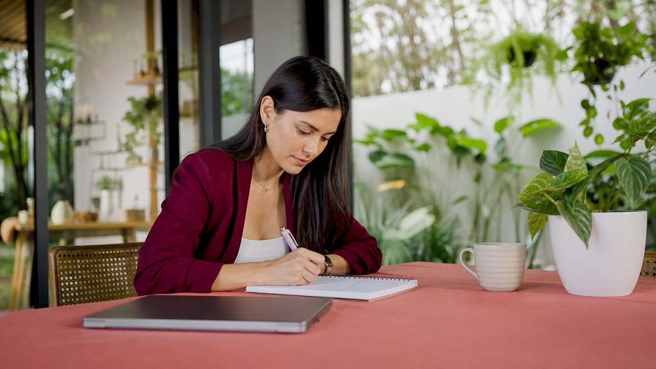 Mujer organizando una estrategia de marketing digital desde su escritorio